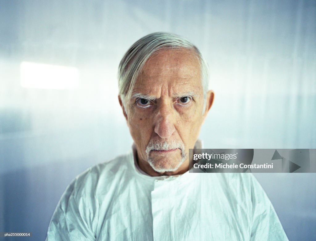 Senior man knitting brows, head and shoulders, front view