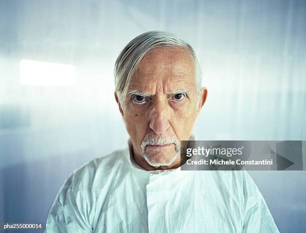senior man knitting brows, head and shoulders, front view - cruel stock pictures, royalty-free photos & images