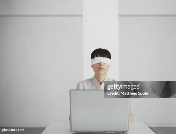 blindfolded woman sitting behind laptop - the challenge stock pictures, royalty-free photos & images