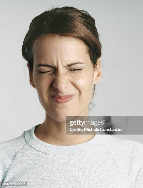 young woman squinting eyes shut, close-up - refusing fotografías e imágenes de stock