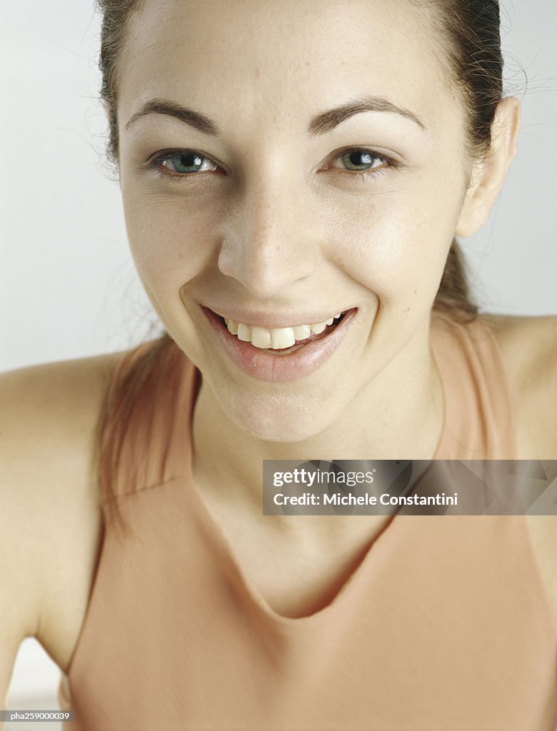 Young woman with hair back smiling, close-up