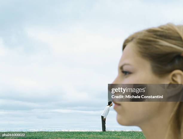 side view of woman's face blurred in foreground, man next to woman's lips in distance - optische täuschung stock-fotos und bilder