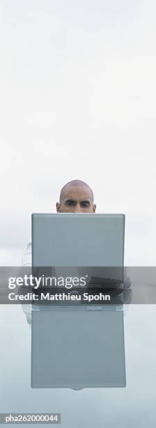 top of man's head seen over back of laptop screen, outdoors - shaved-buzz-cut-back-of-head photos et images de collection