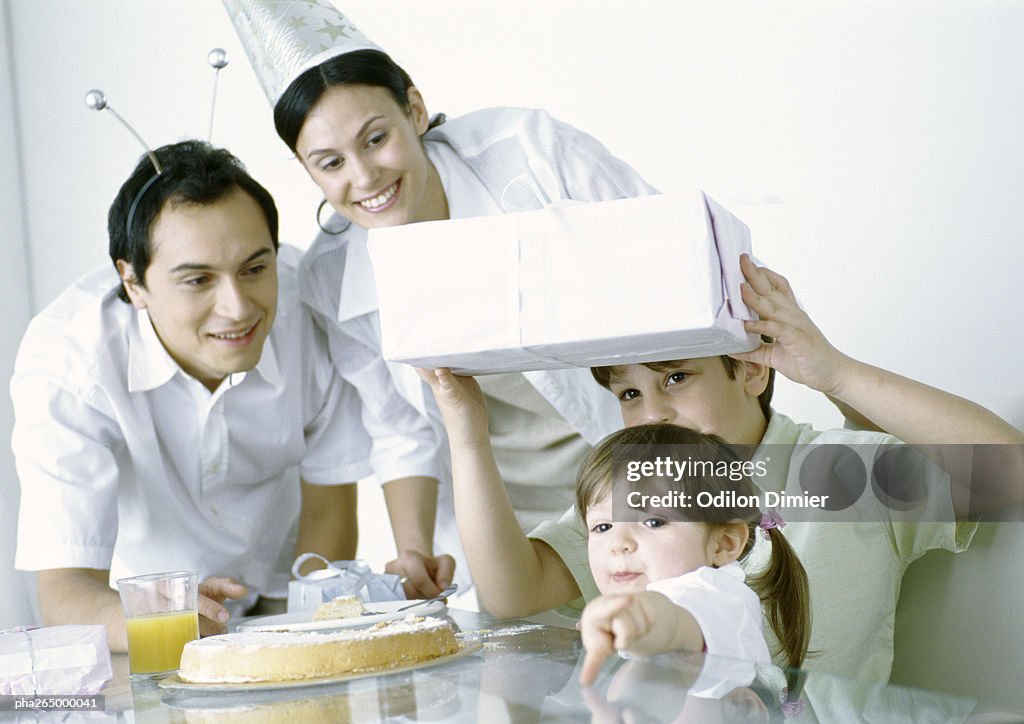 Boy and girl with parents having birthday party