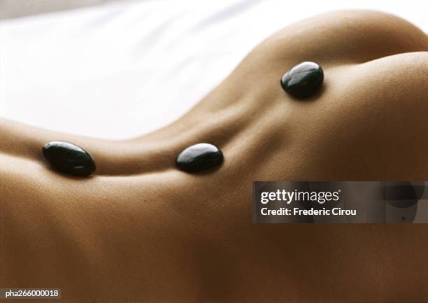 woman's bare back with black stones on spine, close-up - bare bottom women - fotografias e filmes do acervo