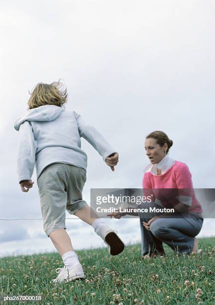 woman crouching holding end of jump rope for boy preparing to jump - world premiere of the end of longing written by and starring matthew perry stockfoto's en -beelden