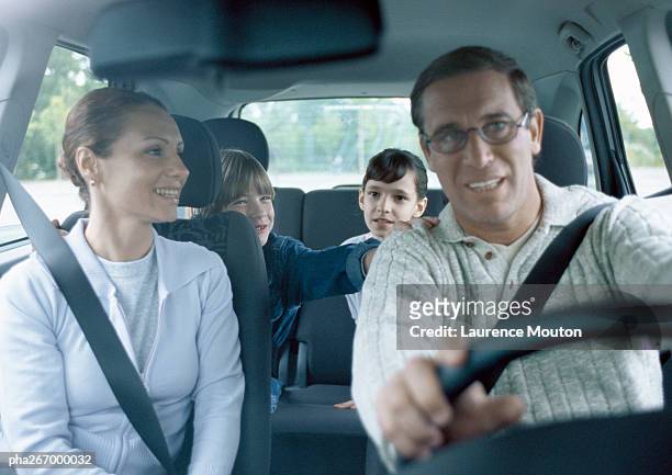 parents with boy and girl in car wearing seatbelts, interior view - driving car front view stock pictures, royalty-free photos & images