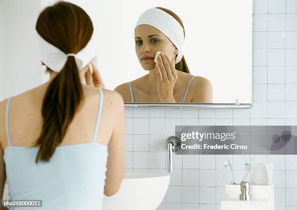 woman washing face in front of mirror - woman applying cotton ball stock pictures, royalty-free photos & images