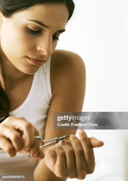 woman cutting nails with nail scissors - nail scissors stock pictures, royalty-free photos & images