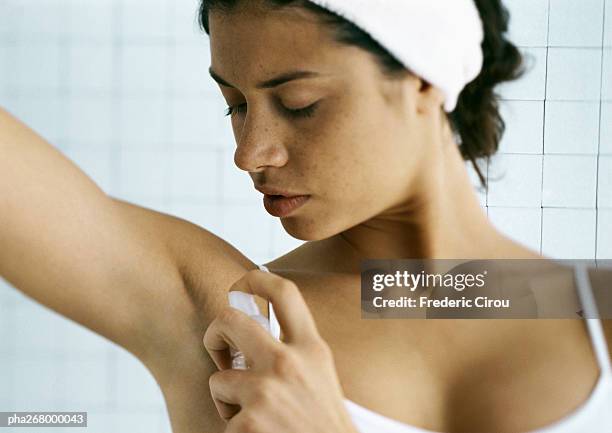 young woman spraying underarm, head and shoulders - perfume sprayer bildbanksfoton och bilder