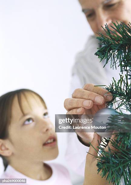 girl and grandfather decorating christmas tree - national youth theatre 60th anniversary gala the story of our youth at 60 stockfoto's en -beelden