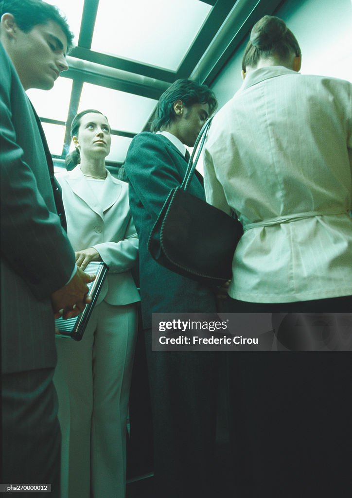 Businesspeople in elevator, low angle view