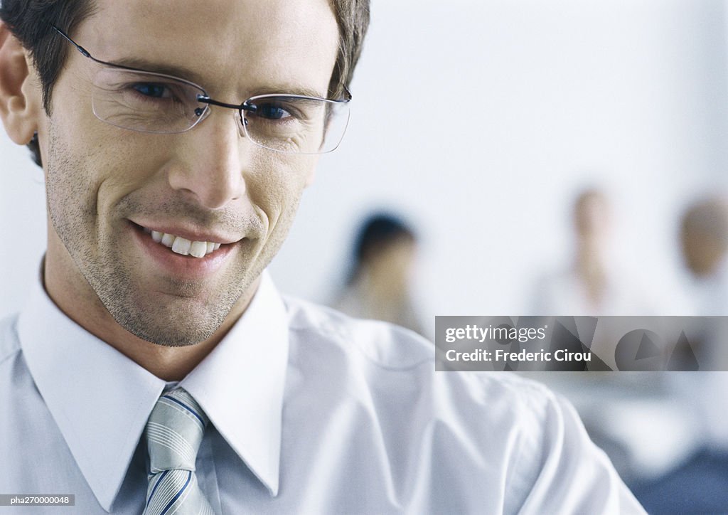 Businessman with glasses, smiling at camera