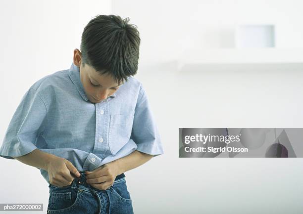 boy fastening belt - belt stockfoto's en -beelden