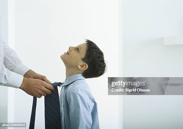 man tying tie around boy's neck - moue de dédain photos et images de collection