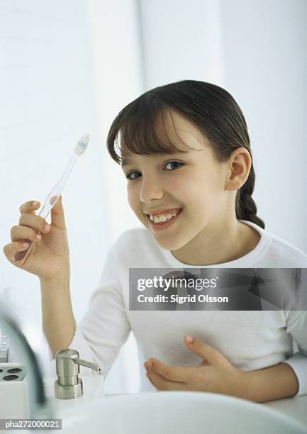 girl holding up toothbrush - bad bangs stock-fotos und bilder