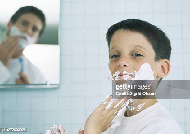 boy with shaving cream on face and hands, man shaving in background - imitator stock pictures, royalty-free photos & images