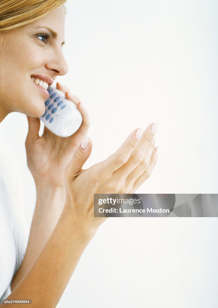 Woman talking on cordless phone and gesturing, side view