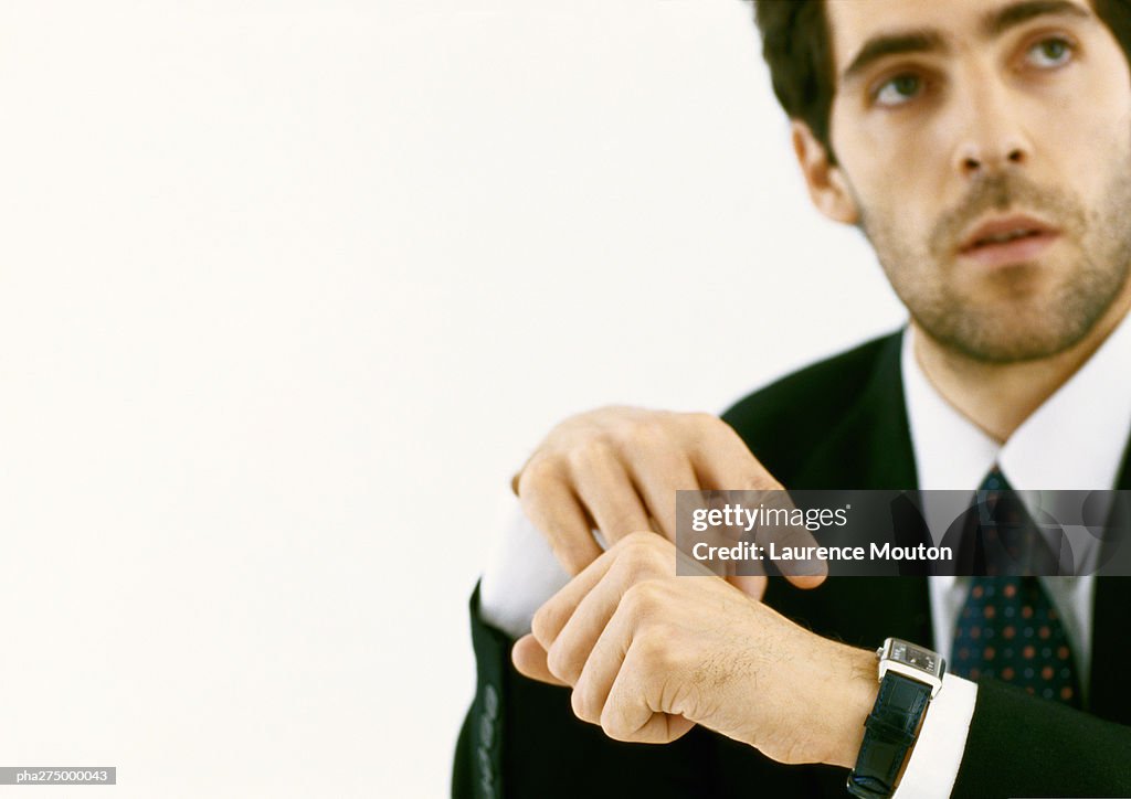 Businessman pointing to watch and looking up