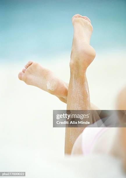 woman lying in sand, close-up of lower legs - woman lying on stomach with feet up fotografías e imágenes de stock
