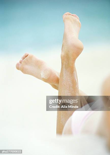 woman lying in sand, close-up of lower legs - woman lying on stomach with feet up stock pictures, royalty-free photos & images