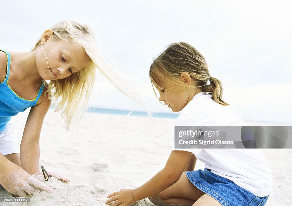 Two girls playing in sand