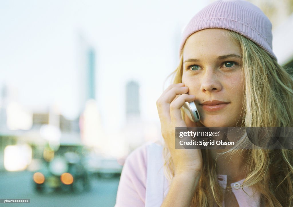 Teenage girl using cell phone in city