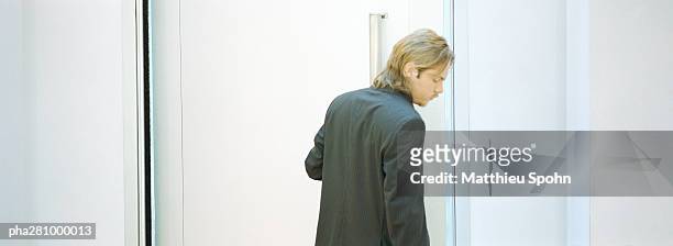 businessman standing next to door, panoramic - door stockfoto's en -beelden
