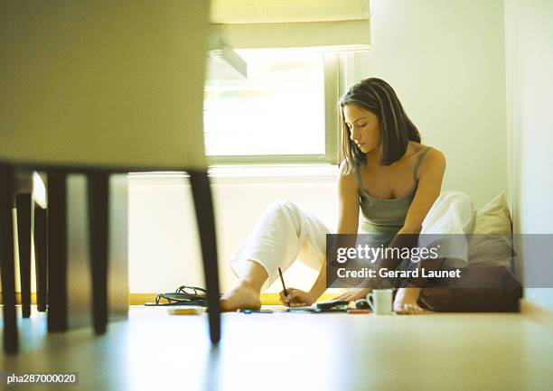 woman sitting on floor, writing - gerrard stock-fotos und bilder