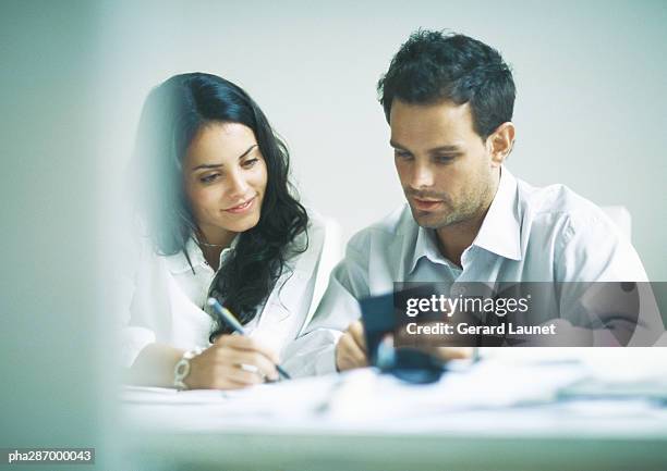 young adults examining documents and calculating - gerrard stock-fotos und bilder