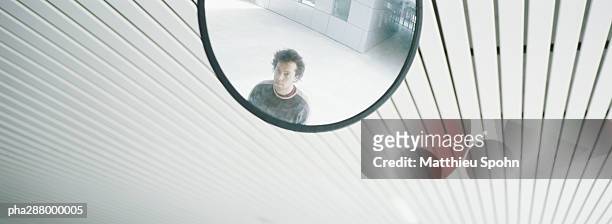 young man's reflection in mirror - intersected stock pictures, royalty-free photos & images