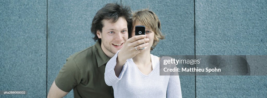 Young couple taking photo with camera phone