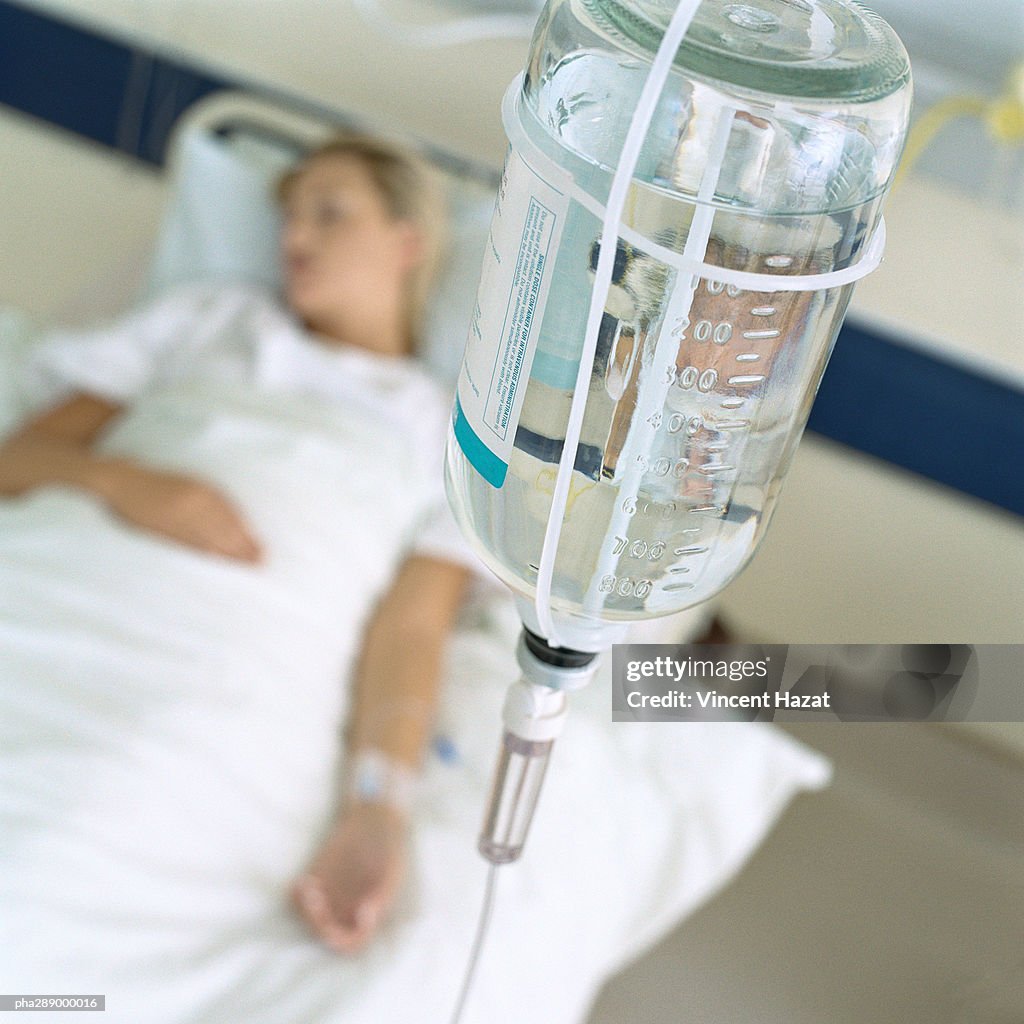 IV and female patient lying in hospital bed