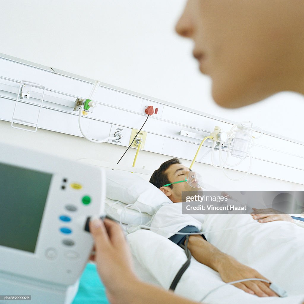 Nurse checking patient's monitor