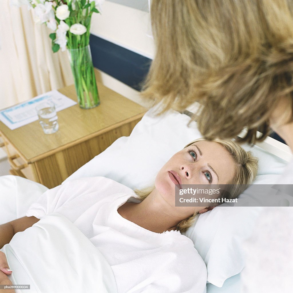 Hospital patient looking up at woman