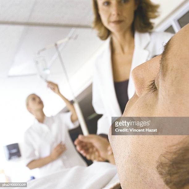 doctor taking patient's pulse in emergency room - unconscious stock pictures, royalty-free photos & images
