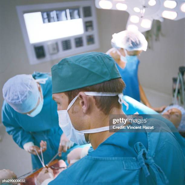 doctors performing operation - chirurgenkappe stock-fotos und bilder