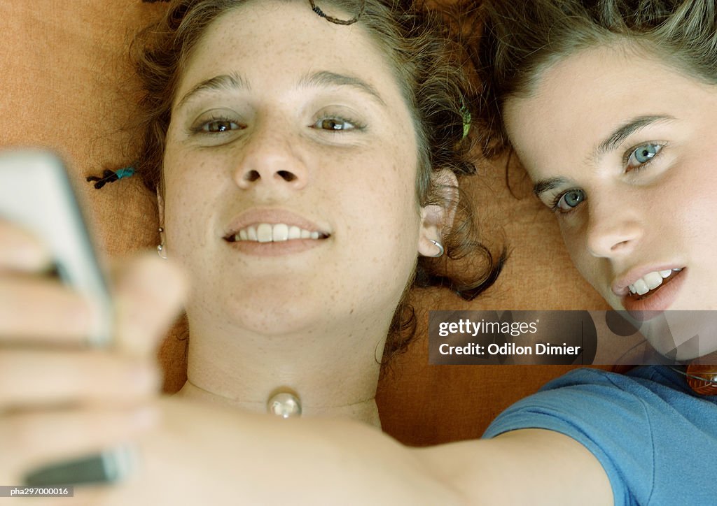 Young women looking at cell phone, close-up