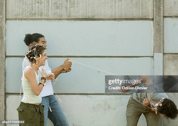 young people playing with party string - party string stock pictures, royalty-free photos & images