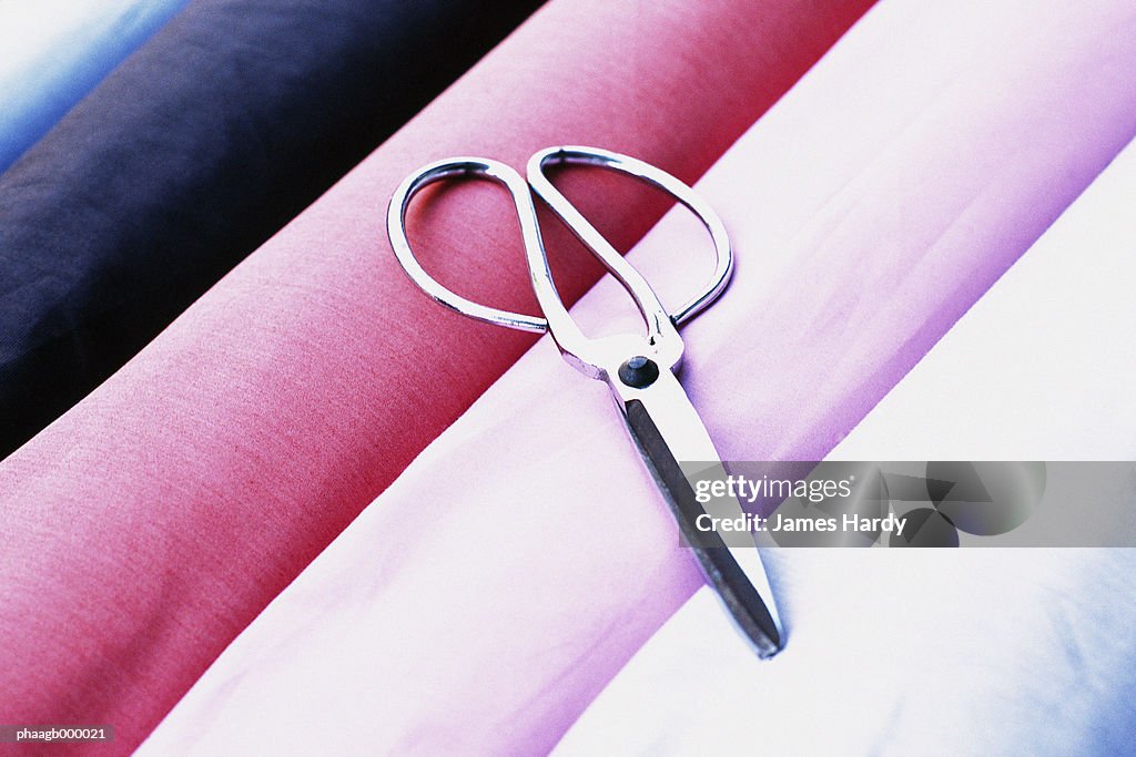 Scissors on rolls of fabric