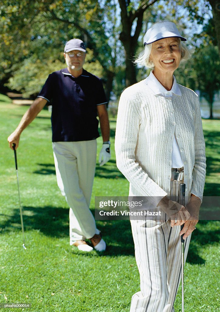 Mature couple playing golf