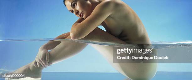 nude woman sitting in water, side view - skinny dipping stock pictures, royalty-free photos & images