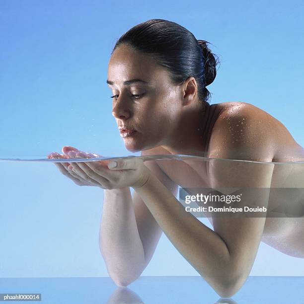 nude woman cupping hands in water, close-up - balneotherapy stock pictures, royalty-free photos & images