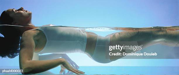 woman floating in water, side view - balneotherapy stock pictures, royalty-free photos & images