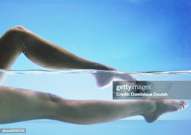 woman's bare legs in water - balneotherapy stock pictures, royalty-free photos & images