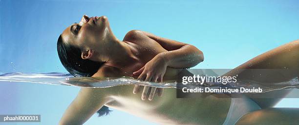 semi-nude woman in water, head back, covering breast - balneotherapy stock pictures, royalty-free photos & images