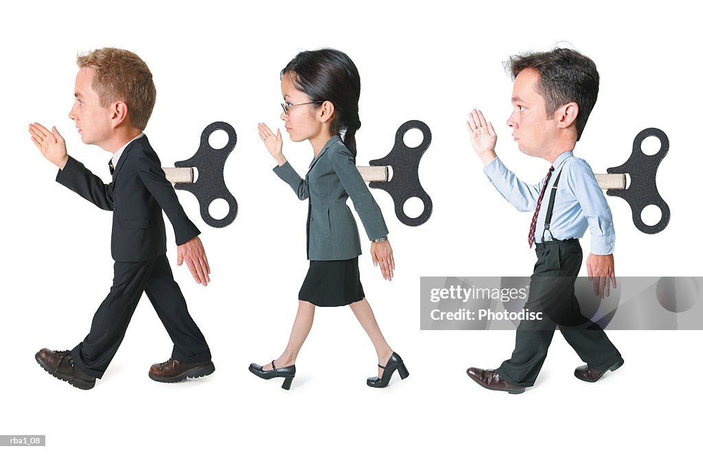 Conceptual caricature of a three business people with wind up cranks in the backs march forward in the same way