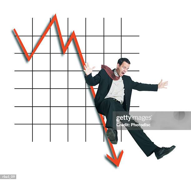 conceptual photo of a caucasian man in a suit as he slides down a plummeting line on a graph - downfall stockfoto's en -beelden