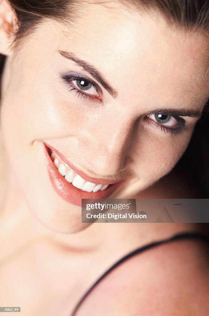 An overhead shot of a young pretty caucasian brunette looking up at the camera and smiles