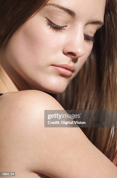 another bare shoulder shot of young caucasian brunette looking down - aother stock pictures, royalty-free photos & images